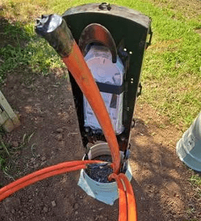 Orange conduit being pulled through a directional bore on a Nosh job site